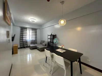 a living room with a table and chairs and a couch at Newport City Home- Naia T3 in Manila