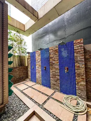 a bathroom with blue tiles on the wall at Convertible Solo Budget Studio in Salcedo Village in Manila