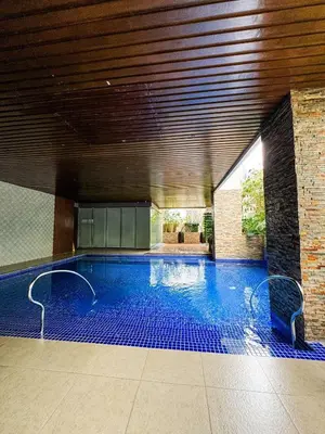 a swimming pool in a building with a ceiling at Convertible Solo Budget Studio in Salcedo Village in Manila
