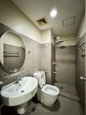 a bathroom with a sink and a toilet and a mirror at Convertible Solo Budget Studio in Salcedo Village in Manila