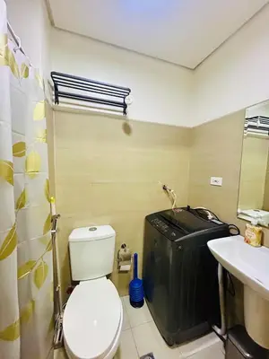 a bathroom with a toilet and a sink at 7 Mins from MOA Comfy Stay with Pool View and WiFi in Manila