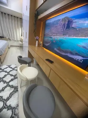 a room with a tv and two chairs and a bed at Field residences Building 9 in Manila