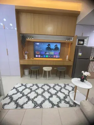 a living room with a tv and a table and chairs at Field residences Building 9 in Manila