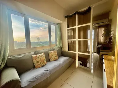 a couch in a room with a large window at SMDC Coast Residences Levi & Moon in Manila