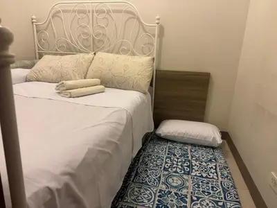 a bedroom with two twin beds with a rug at SMDC Coast Residences Levi & Moon in Manila