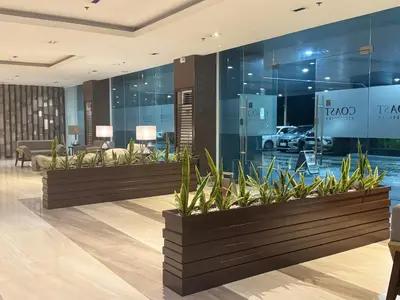 a lobby with a row of potted plants at SMDC Coast Residences Levi & Moon in Manila