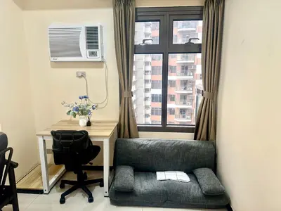 a room with a chair and a desk and a window at Luxurious Haven in the Sky in Manila