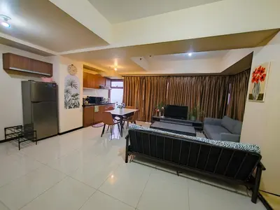 a living room with a couch and a kitchen at Luxurious Haven in the Sky in Manila