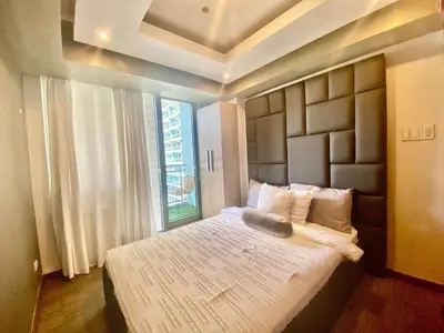 a bedroom with a large bed with a large window at Leisure escape staycation Azure in Manila