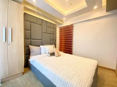a bedroom with a large bed with a large headboard at Leisure escape staycation Azure in Manila