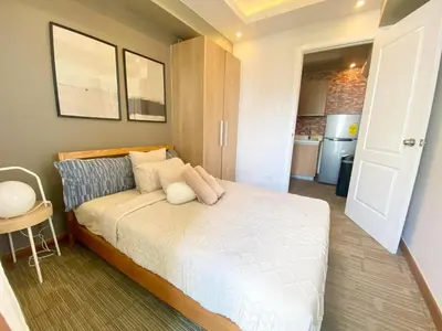 a bedroom with a bed and a kitchen at Leisure escape staycation Azure in Manila