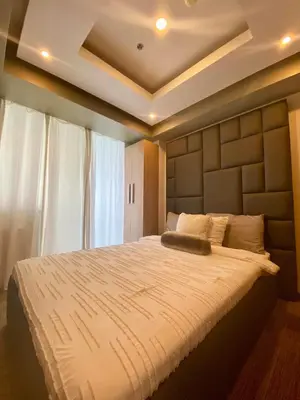 a bedroom with a large bed with a large headboard at Leisure escape staycation Azure in Manila