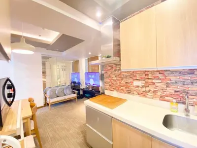 a kitchen with a sink and a living room at Leisure escape staycation Azure in Manila