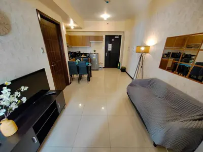 a living room with a couch and a kitchen at Manila Bay View - 1BR with balcony in Manila
