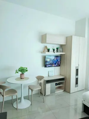 a living room with a table and chairs and a tv at The Catalina at The Beacon Makati in Manila