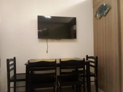 a dining room table with chairs and a television on the wall at Lynx staycation in Manila
