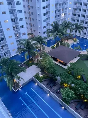 an overhead view of a pool with palm trees and buildings at Lynx staycation in Manila