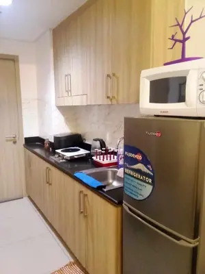 a kitchen with a stainless steel refrigerator and a microwave at Lynx staycation in Manila