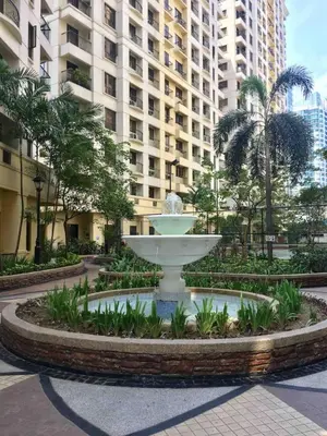 a fountain in front of a large building at Rustic 1 BR Apartment Poolside View in Manila