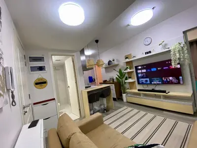 a living room with a couch and a flat screen tv at Leisure escape Azure in Manila