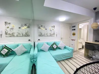 a living room with a blue couch and a sink at Leisure escape Azure in Manila