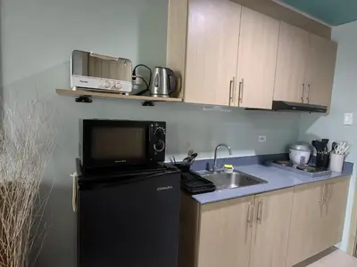 a kitchen with a black refrigerator and a sink at Seaside Sanctuary and Beach Vibes in Manila