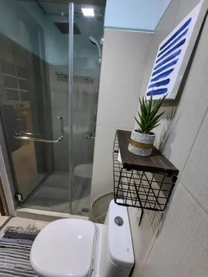 a bathroom with a toilet and a glass shower at Seaside Sanctuary and Beach Vibes in Manila