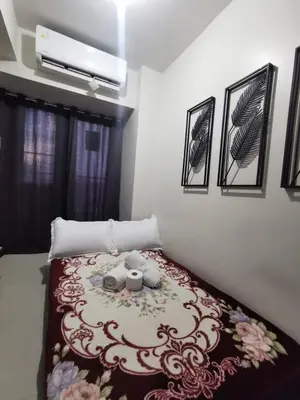 a bedroom with a bed with a flower pattern on it at Aldo Staycation mall of Asia in Manila