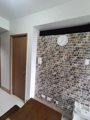 a brick wall with a clock on a wall at Aldo Staycation mall of Asia in Manila