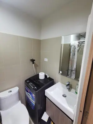 a bathroom with a white toilet and a sink at Aldo Staycation mall of Asia in Manila
