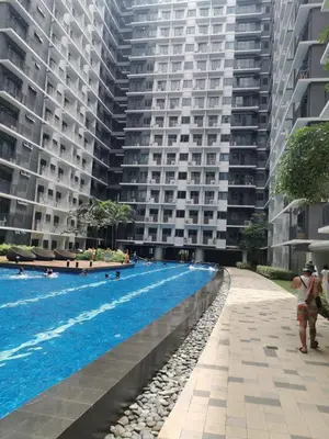 a swimming pool in front of a large building at Aldo Staycation mall of Asia in Manila
