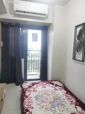 a bedroom with a bed in front of a window at Aldo Staycation mall of Asia in Manila