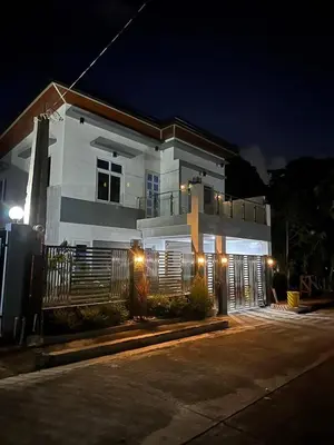 a white house with a gate at night at Casa MiKulai