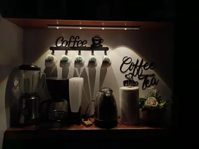 a kitchen counter with a coffee maker and a shelf with writing at Casa MiKulai