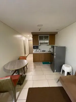 a small kitchen with a table and a refrigerator at Antel Spa Residences 7OB in Manila