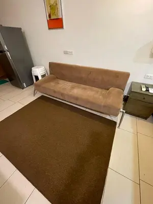 a brown couch in a living room with a table at Antel Spa Residences 7OB in Manila