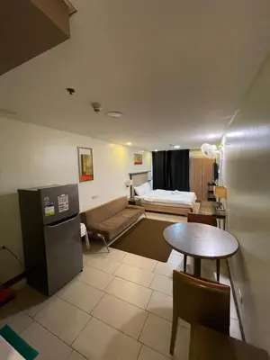 a living room with a bed and a table at Antel Spa Residences 7OB in Manila