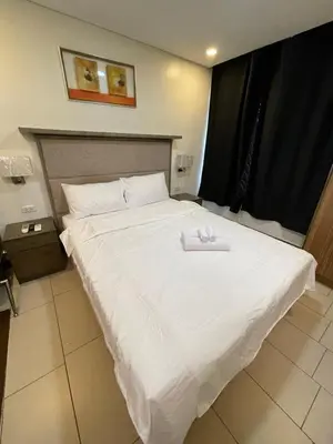 a large white bed with two towels on it at Antel Spa Residences 7OB in Manila