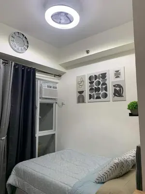 a bedroom with a bed and a clock on the ceiling at EK's Place in Manila