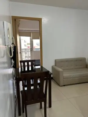 a living room with a table and chairs and a couch at Solemare Parksuites with balcony in Manila