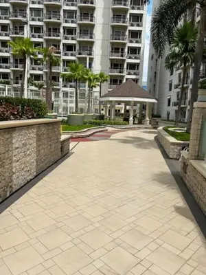 a walkway in a city with palm trees and buildings at Solemare Parksuites with balcony in Manila