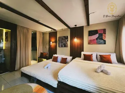 a hotel room with two beds with towels on them at El Nissi Staycation, THE DELUXE CABIN, Enchanted Kingdom in Santa Rosa