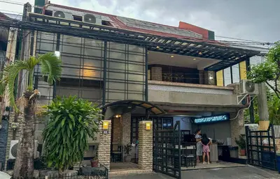 a woman standing in front of a building at Manila Gateway Hostel in Manila
