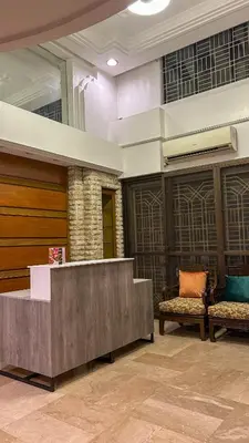 a lobby with a reception desk and two chairs at Manila Gateway Hostel in Manila