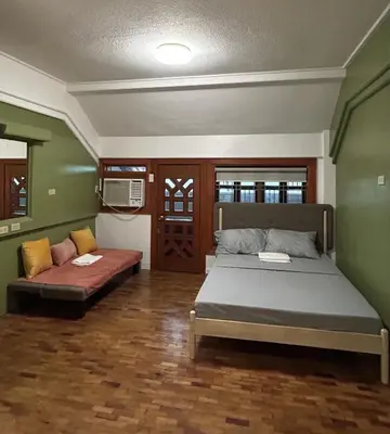 a bedroom with a bed and a couch in it at Manila Gateway Hostel in Manila