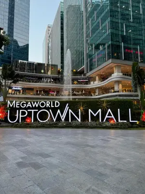 a sign for the mex world uptown mall in a city at Stylish 1BR with balcony inside BGC at Uptown Parksuites - 20d in Manila