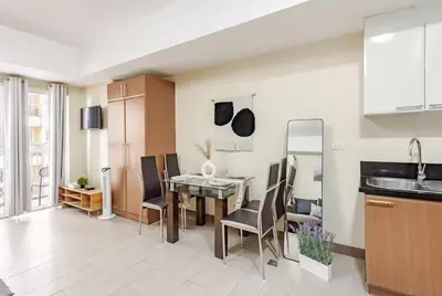 a kitchen and dining room with a table and chairs at Classy Venice Grand Studio Balcony Pet friendly, WiFi & Pool in Manila