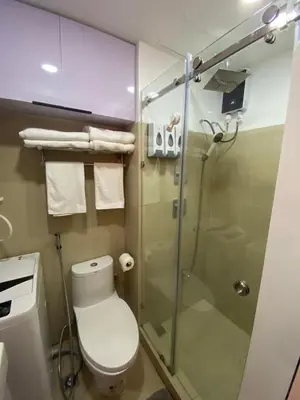 a bathroom with a toilet and a glass shower at HomeSuiteHome, Shore 3 Residences Moa Complex, Pasay City in Manila