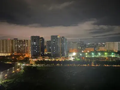 a city lit up at night with buildings at HomeSuiteHome, Shore 3 Residences Moa Complex, Pasay City in Manila