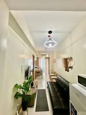 a living room with a couch and a table at Mall of Asia Staycation with fast wifi and google tv in Manila